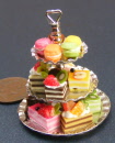 a dolls house miniature 3 tier cake stand with cakes