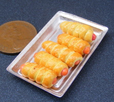 dolls house miniature sausage rolls in a large tray