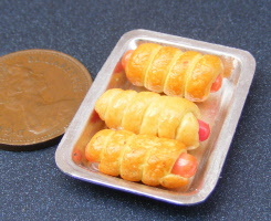 dolls house miniature sausage rolls in a small tray